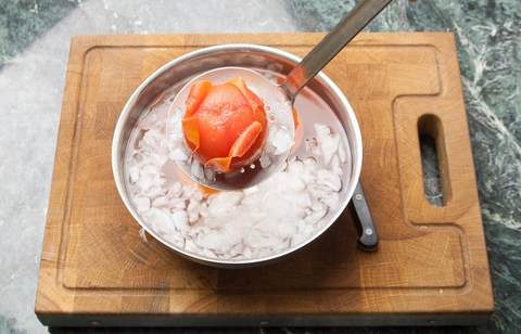 blanchierte Tomaten aus dem kochendem Wasser in das Eiswasser legen