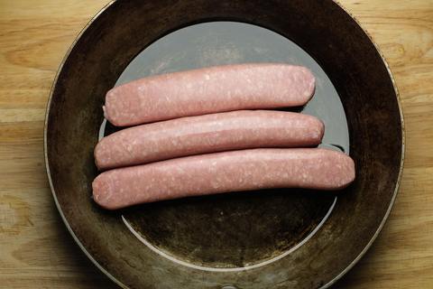 Frische, rohe Bratwürste in der Pfanne