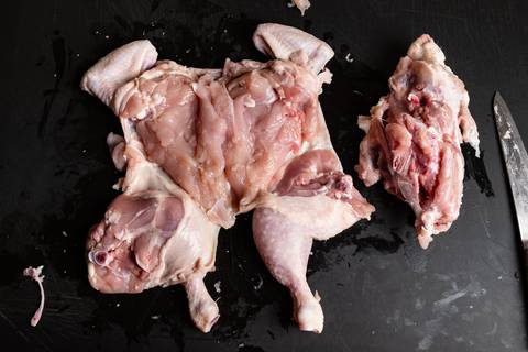 Entbeintes Hähnchen mit Schenkel und Flügel und sichtbarer Karkasse