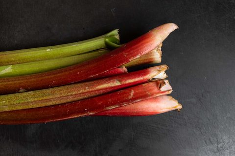 Frische, rote und grüne Rhabarberstangen auf dunklem Untergrund