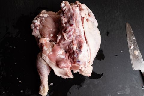 Ganzes Huhn von der Rückseite Hähnchenkeulen und Hähnchenbrust entbeinen