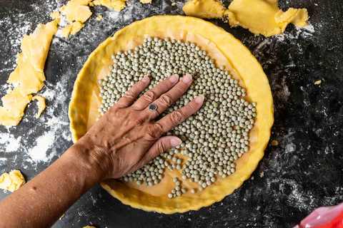 Mürbteig blind backen: Tarteboden mit Backpapier und getrockneten Erbsen zum Blindbacken