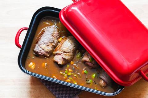 Rinderrouladen gebraten im Bräter mit Soße angegossen vor dem Schmoren mit Deckel