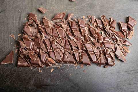 Fein gehackte dunkle Schokolade auf einem Schneidbrett für Mousse au Chocolat