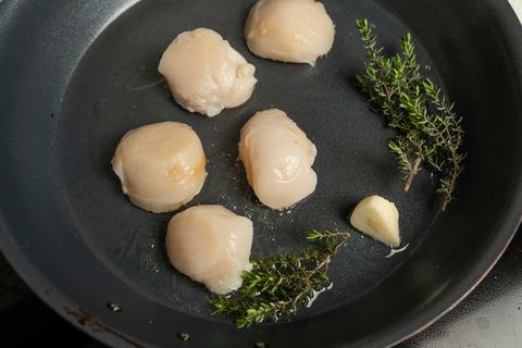Rohe Jakobsmuscheln mit Thymian und Knoblauch in der Pfanne